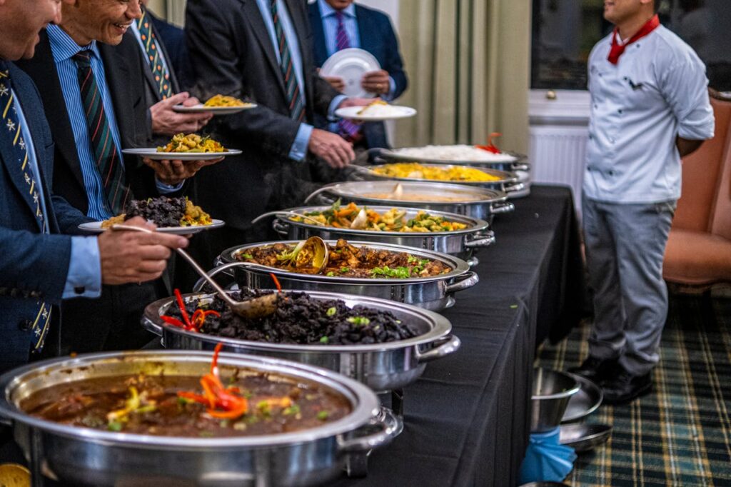 pexels-photo-18749086 Business professionals in suits enjoy a diverse buffet lunch selection at a formal event.